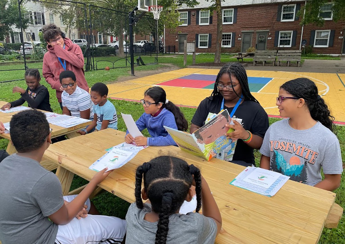 children gathered around an outdoor table with weather certificates