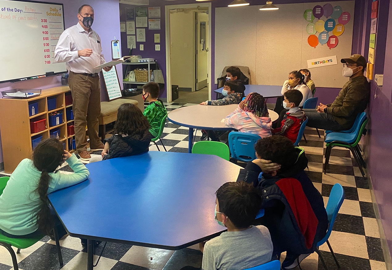 Adult reading aloud to a group of kids