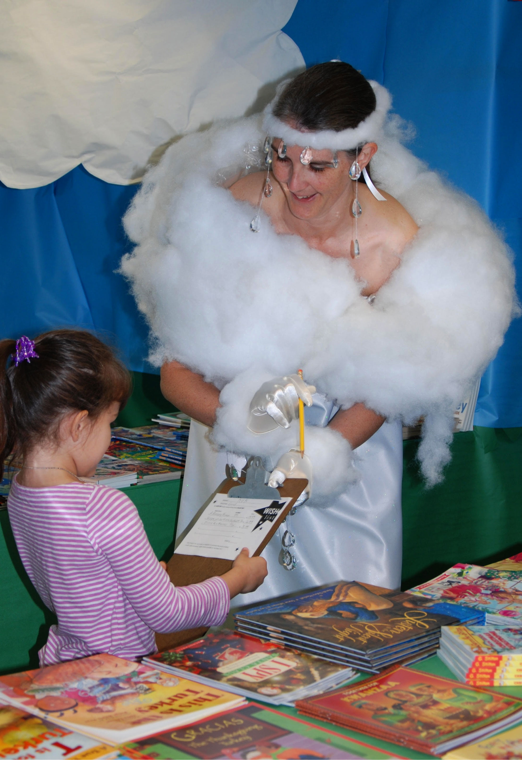 Woman dressed as a cumulus cloud sharing books with young reader
