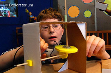 child with cardboard model of a moving machine