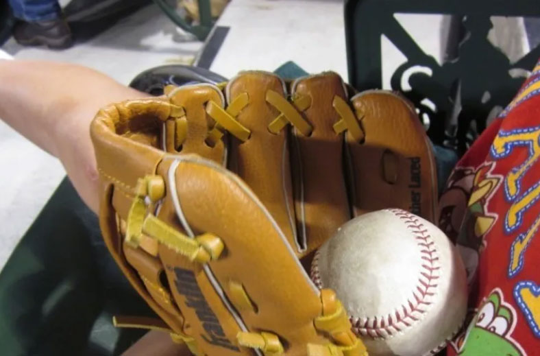photo of a baseball mitt with a baseball inside it