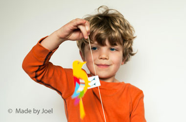 boy holding a paper bird on a string