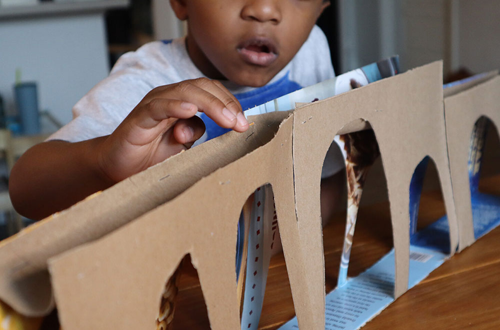 child building a cardboard aqueduct