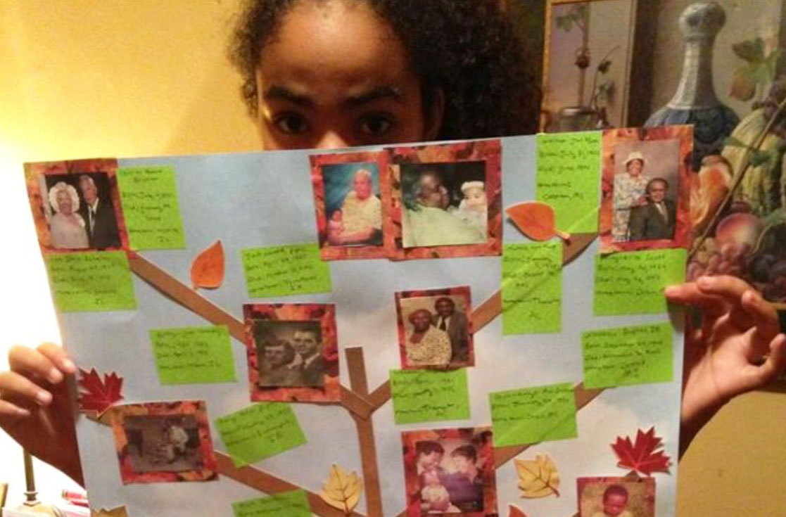 young girl holding up DIY family tree