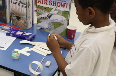 photo of a boy assembling a loopy plane