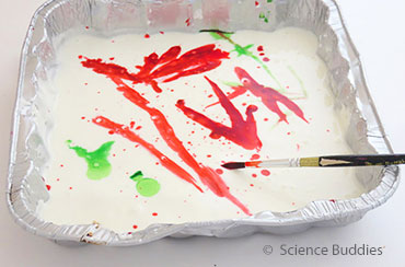 photo of a rectangular foil container with paint streaks and a paint brush