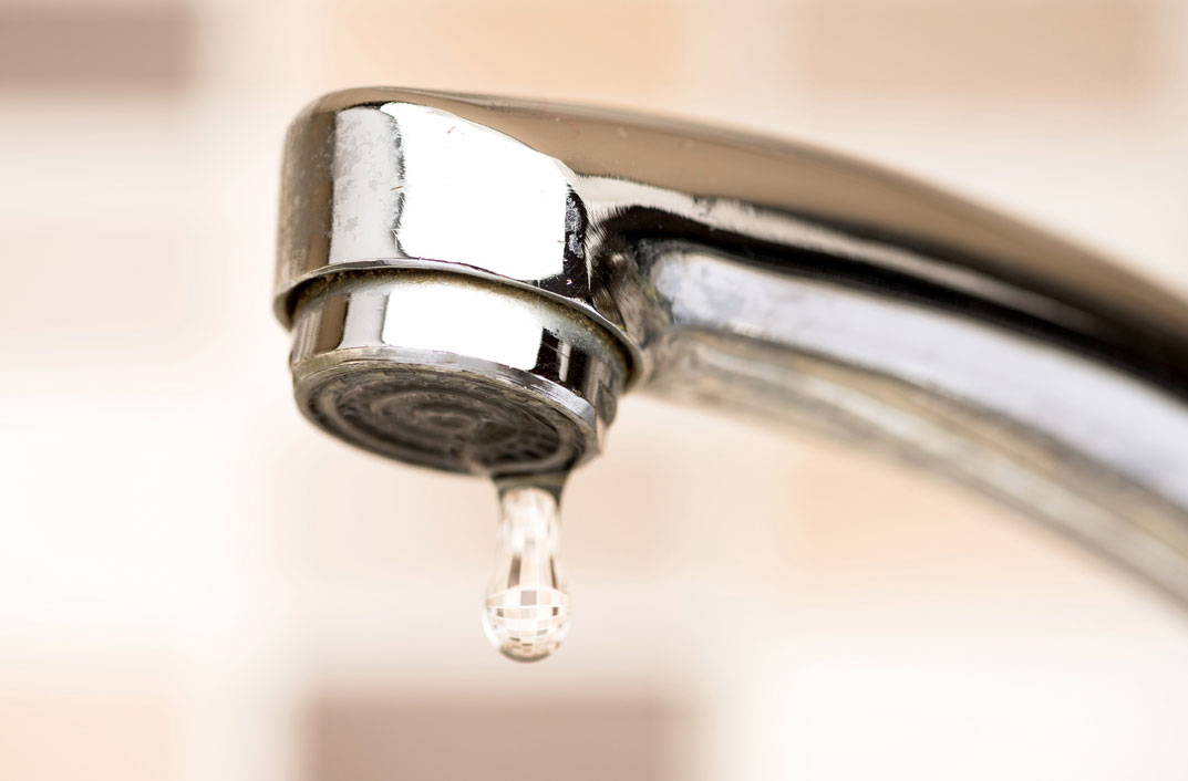 drop of water coming out of a sink faucet