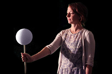 Girl holding Moon model to demonstrate changing phases