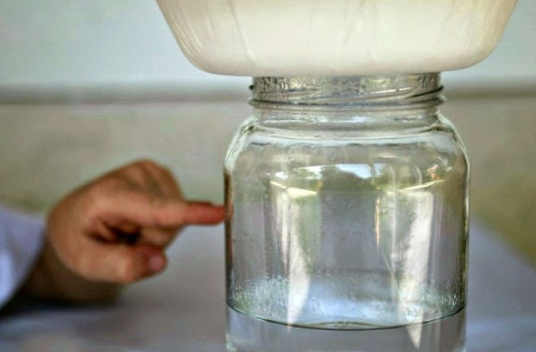  jar of water that has a bowl on top of it