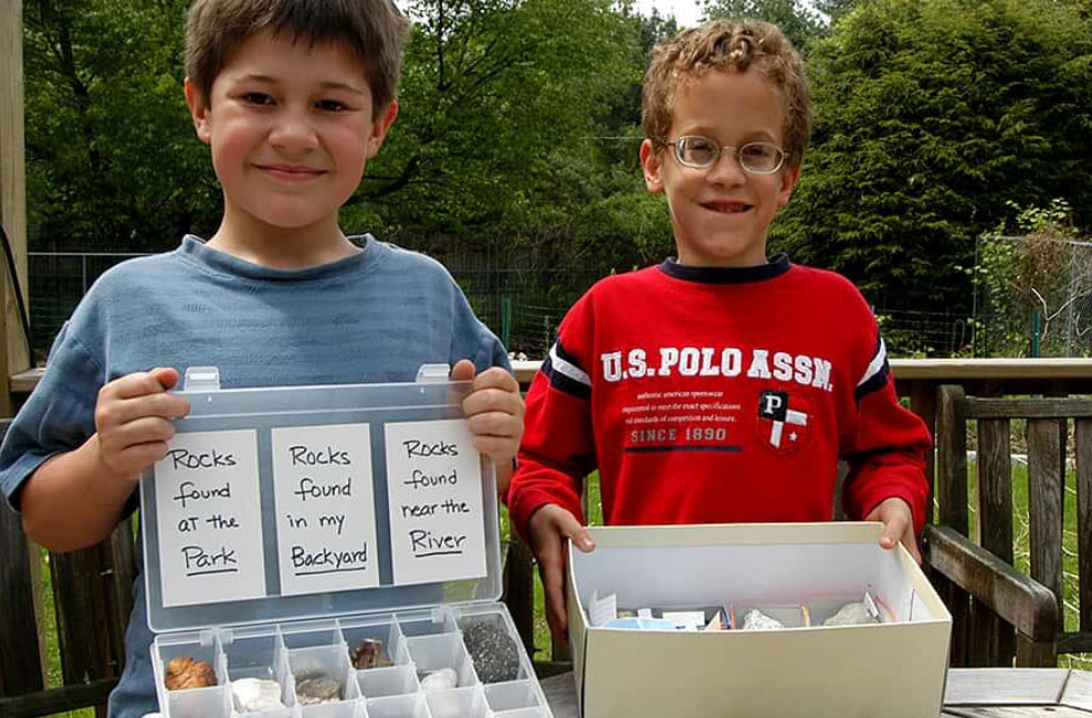 two young boys showing off their rock collections