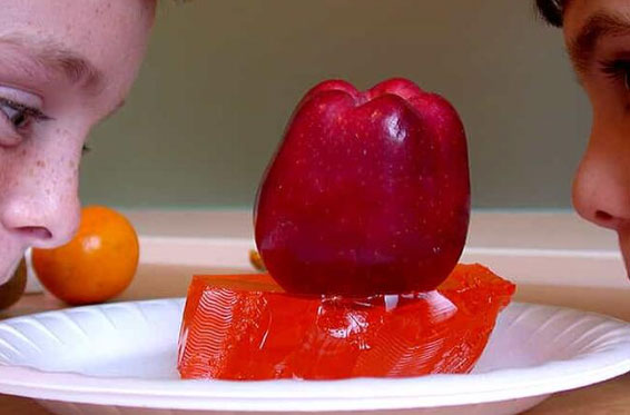 red apple sitting on top of plate of red jello