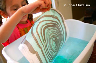 photo of kid holding suminagashi style painting