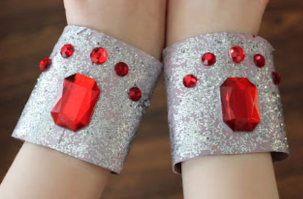close-up of child wearing silver cuffs covered in red stones