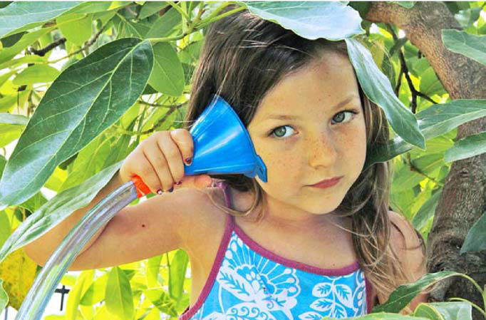 Girl listening to funnel attached to a tube