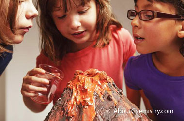 three girls looking at a homemade volcano