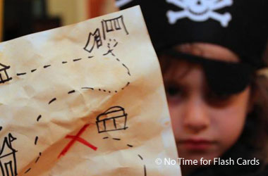 child dressed like a pirate holding up treasure map