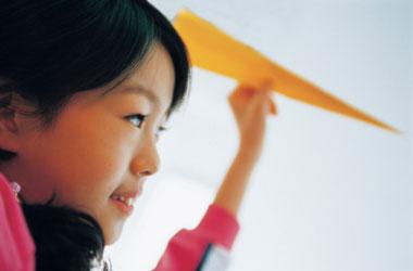 girl throwing a paper airplane