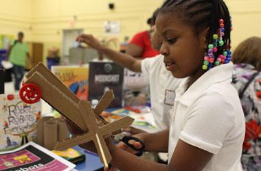 a young girl working on her invention