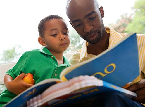 Man and boy reading together.