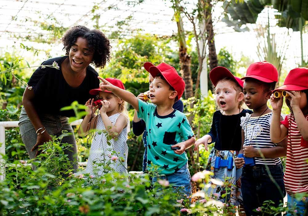 diverse group of young children on a summer field trip to look at plants