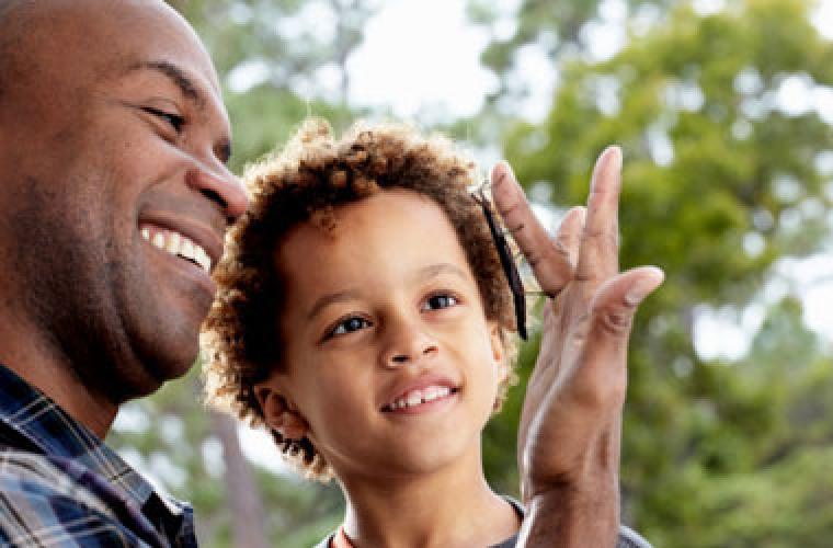 young child and a man with a bug on his finger