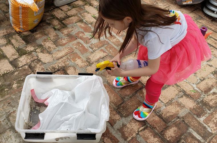 Young girl creating a backyard watershed model