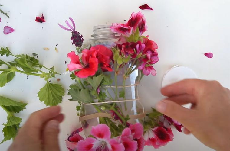 Flowers attached to the outside of a plastic bottle.