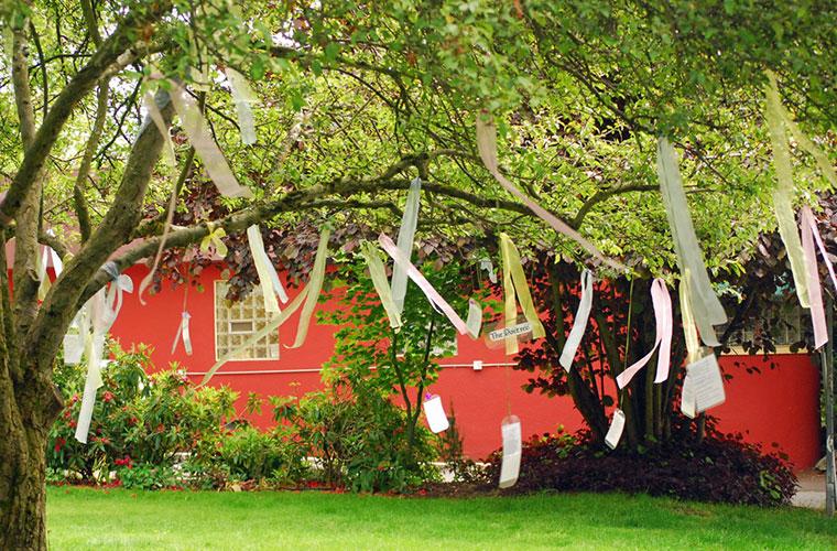 Strips of paper with poetry hanging from a tree outside