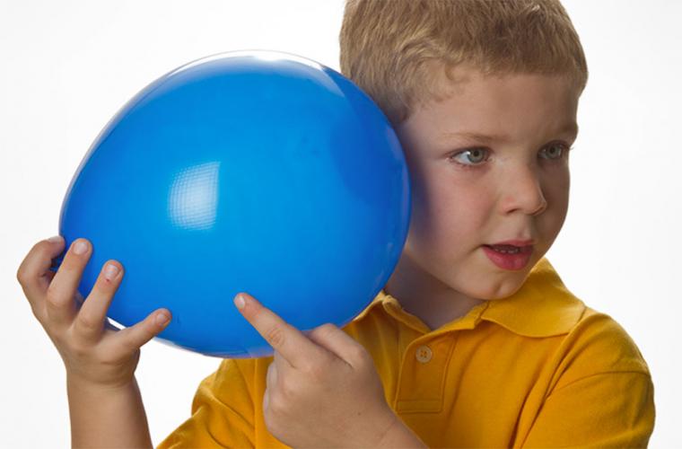 child listening to sounds through a balloon