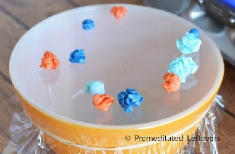 crumpled paper balls on DIY drum made from a bowl and plastic wrap