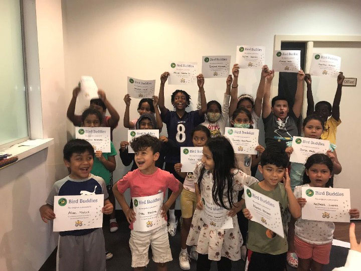 Multicultural group of young kids holding up their summer learning certificates